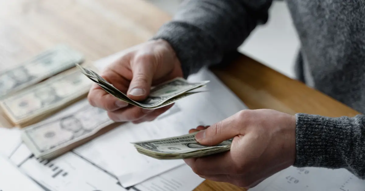 A person counting currency notes and keeping them separately