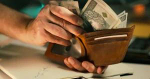 Some currency notes being taken out of a purse