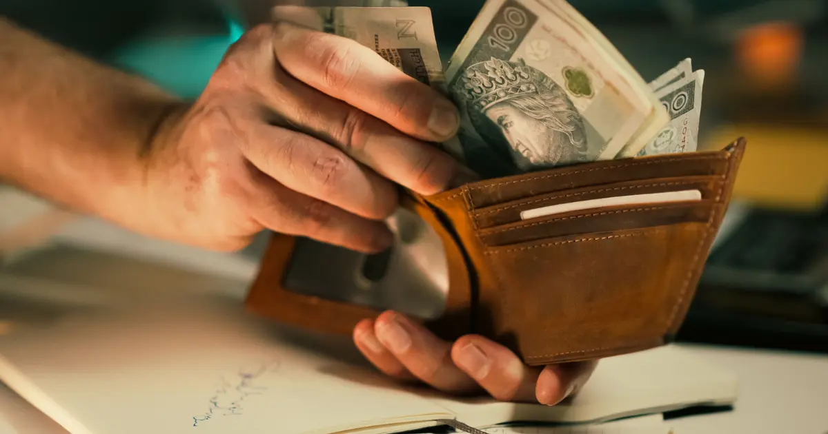 Some currency notes being taken out of a purse